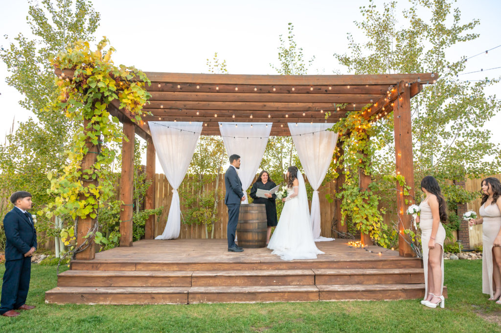 Bride and groom exchanging their vows during the ceremony at balisteri vineyards wedding venue in Denver Colorado