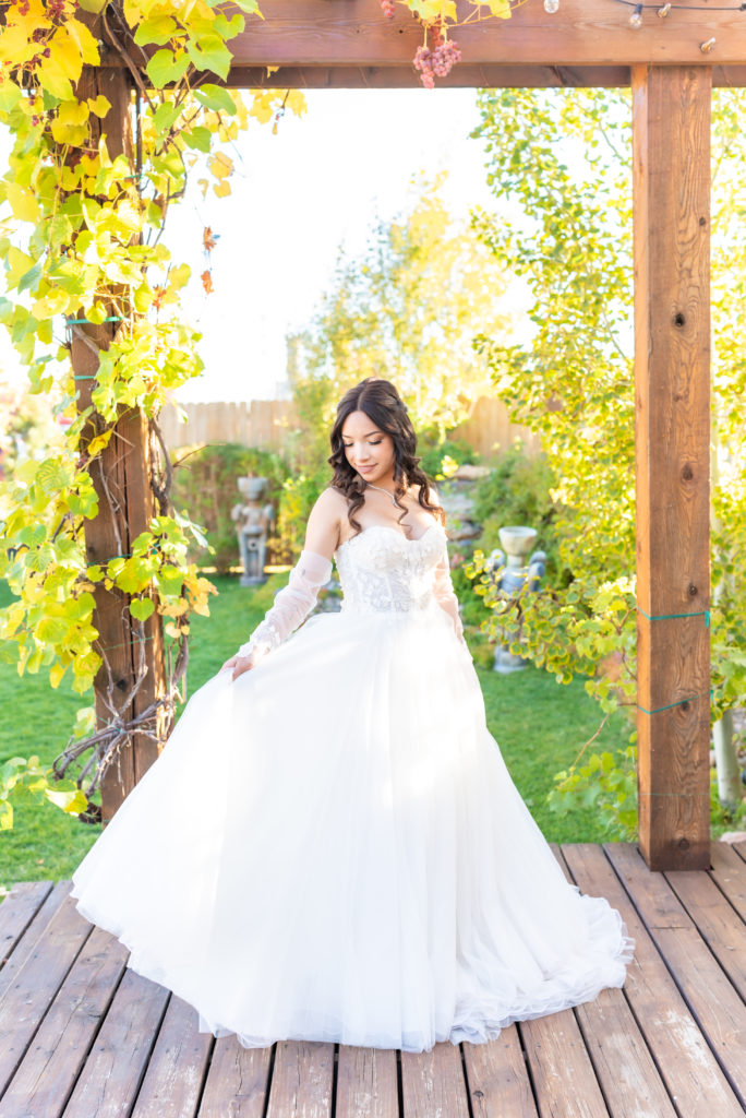 Bride looking down holding her dress at The Balisteri Vineyards Denver Colorado