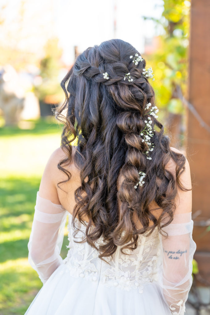 Bride seen from the back, with flowers braided through her hair