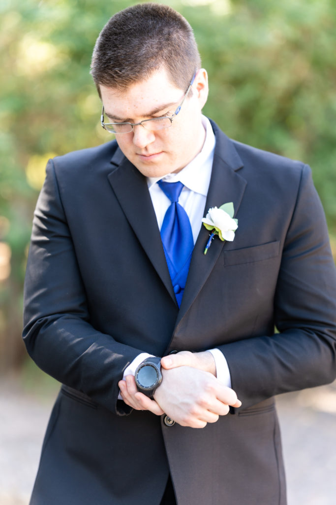 Groom Portrait Photo fixing his watch on wedding day at Hudson Gardens and Event Center Wedding Venue. 