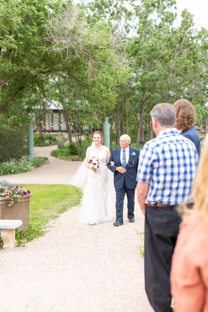 Bride walking down the aisle with her father at Hillside Gardens and Event Center.