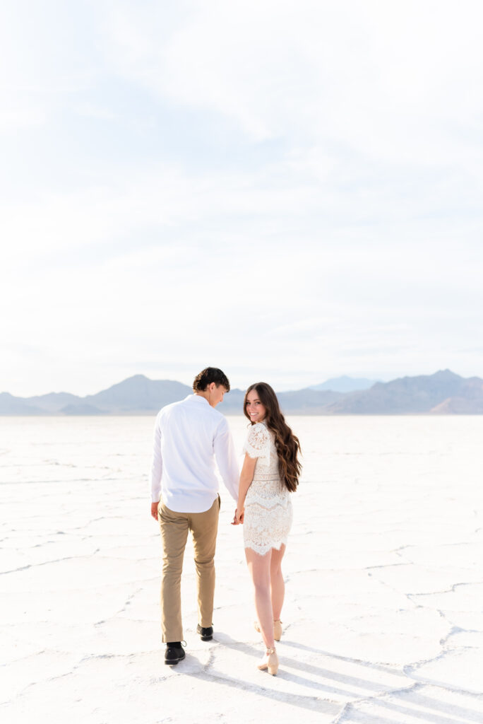 Couple walking out towards mountain views while holding hands during Colorado Springs engagement photoshoot