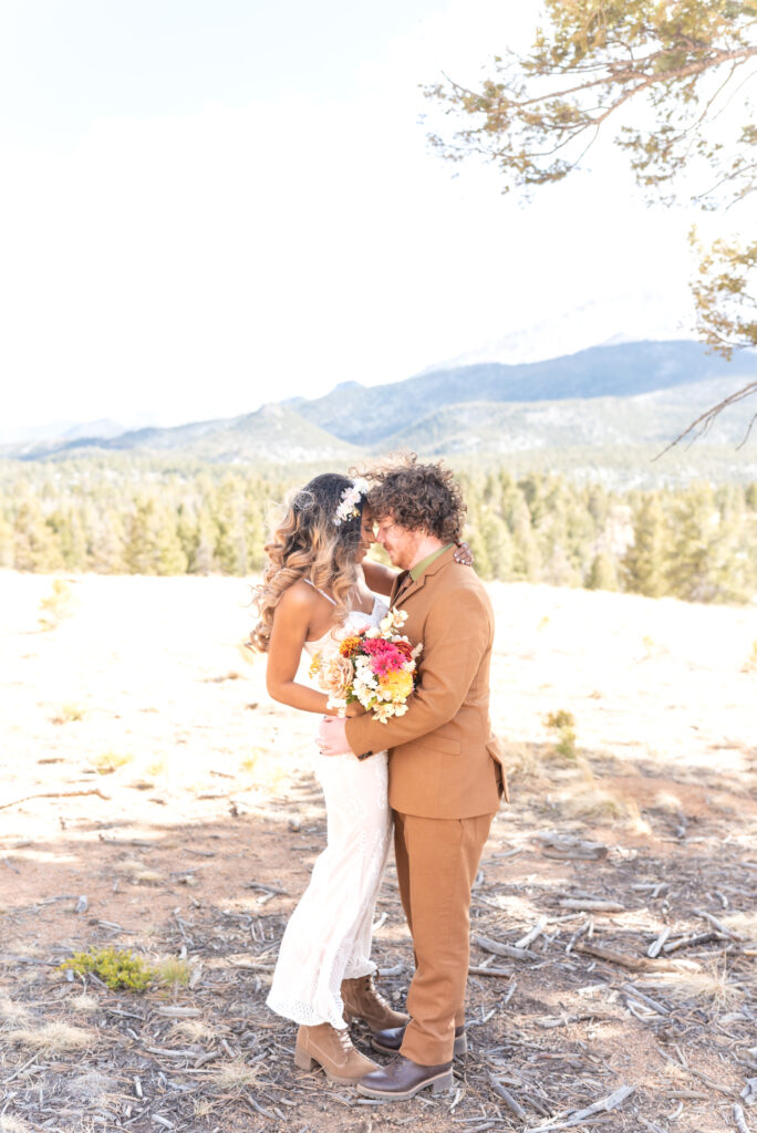 Bride and groom hugging each other in the mountains at pikes peak mountain