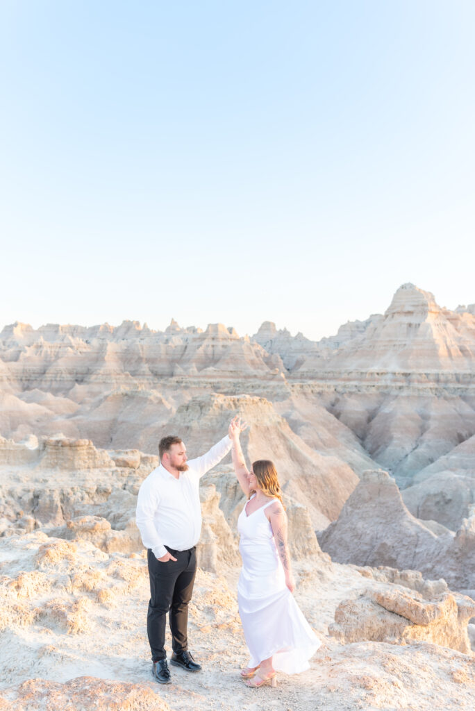 Groom and his bride dancing together on their elopement day at badlands