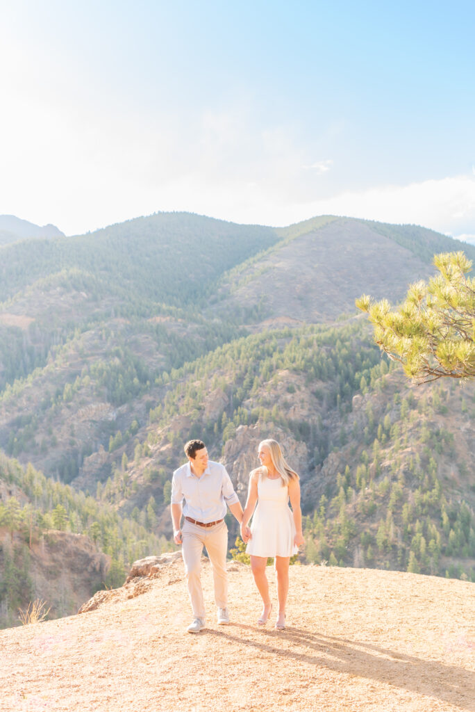Couple walking holding hands together in the Colorado mountains for their engagement photoshoot