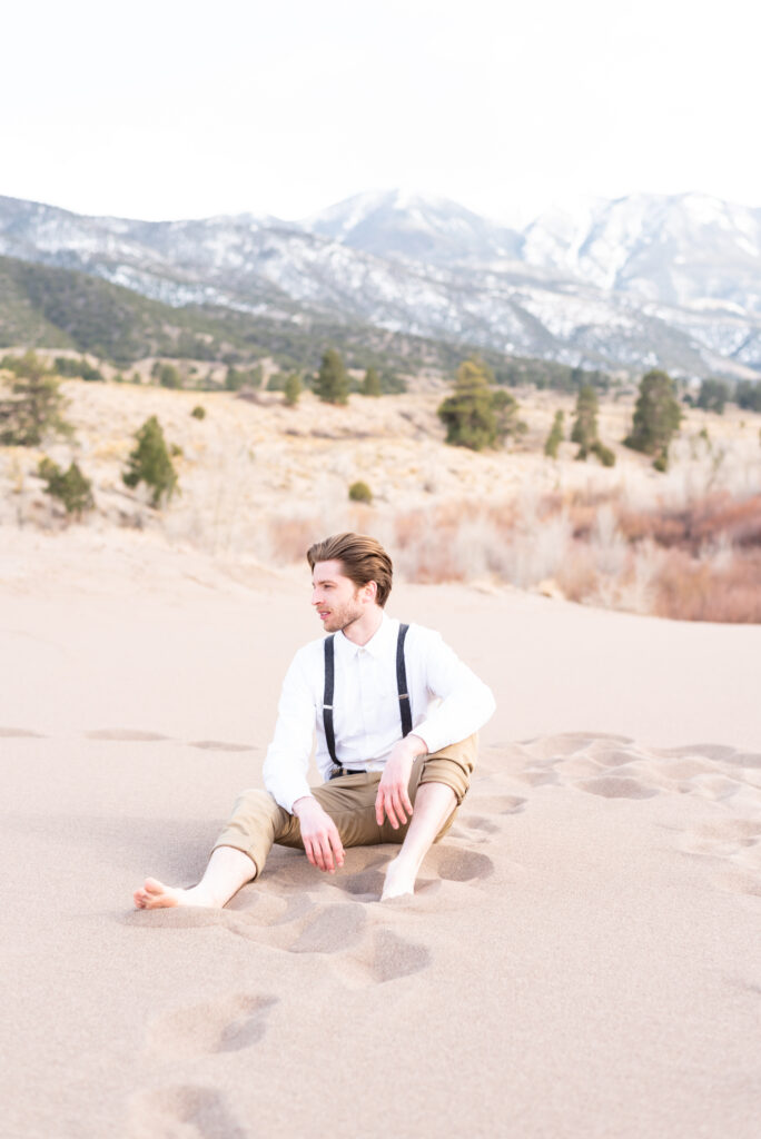 Groom sitting on the sand at great sand dunes national park