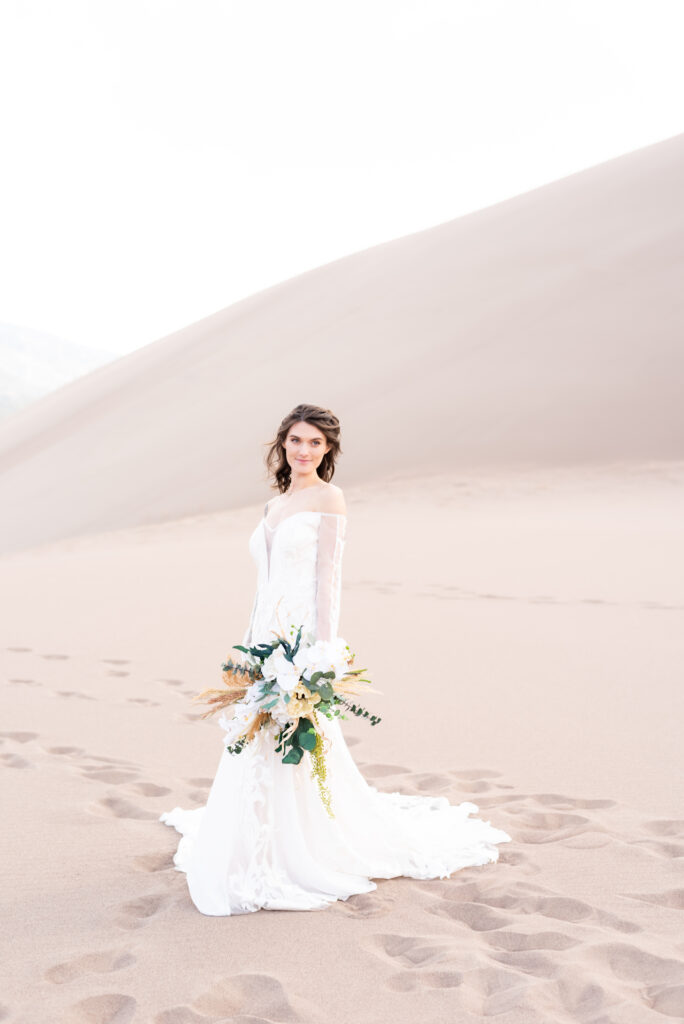 Bride holding her flower bouquet at the great sand dunes park