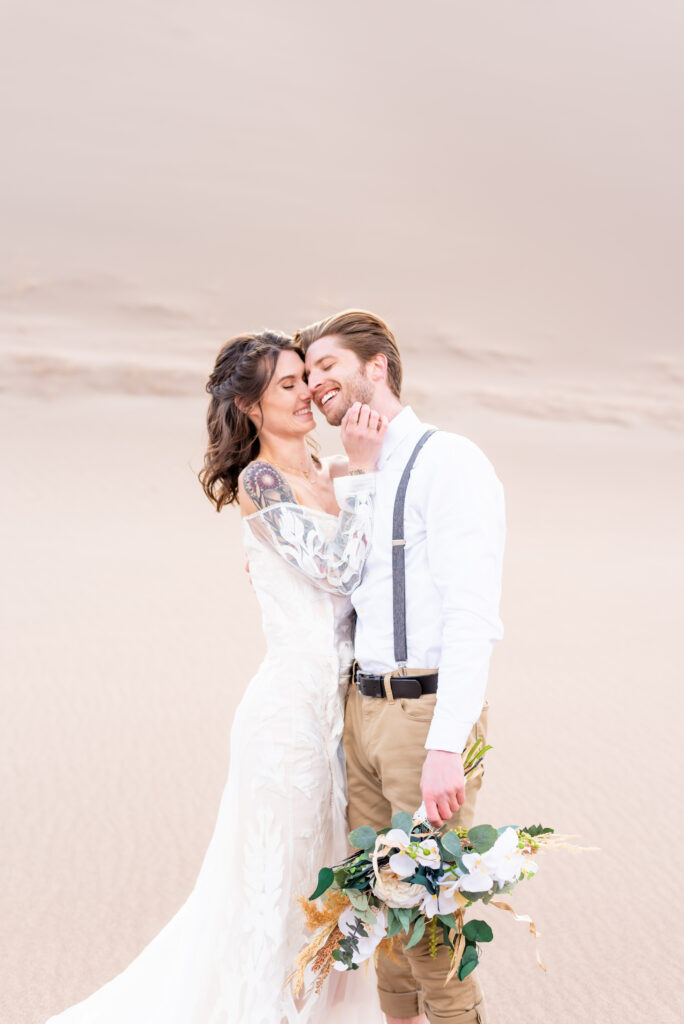 Bride and groom laughing together on their elopement day at great sand dunes national park
