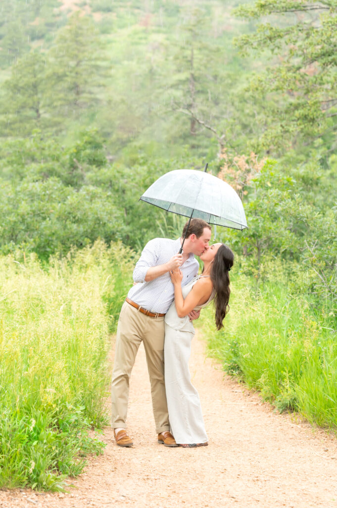 Couple kissing under the umbrella to celebrate their engagement in Colorado Springs 