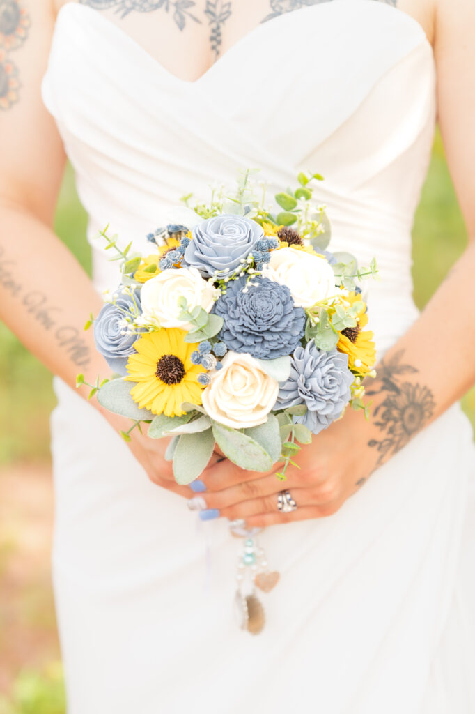 Bride holding bouquet of yellow, blue, and white flowers