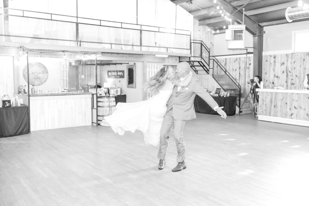 Groom twirling his bride around during their first dance together at red rocks barn