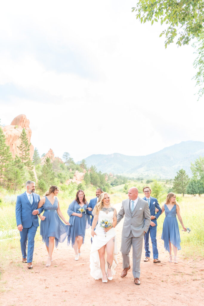 Bridal party walking together in celebration of wedding day at red rocks barn in Colorado Springs 
