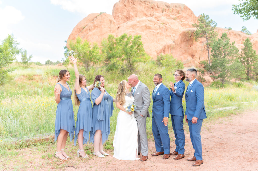 Bride and groom kissing and everyone else cheering to celebrate at red rock canyon open space 