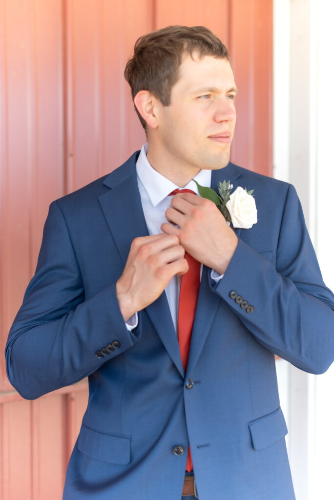 Groom adjusting his tie on his wedding day at Venetucci Farm wedding venue in Colorado
