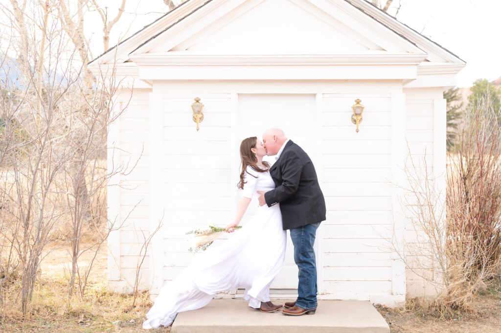 Couple celebrating with a kiss in the front of the American Mothers Chapel