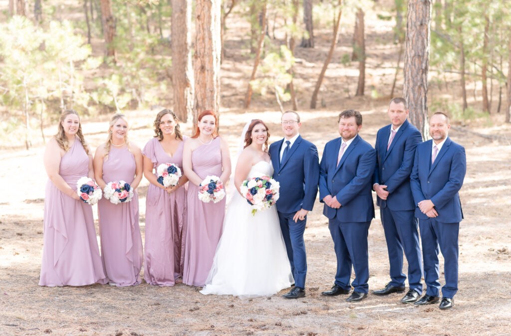 The whole bridal party standing next to each other smiling for a photo at Black Forest By Wedgewood wedding venue