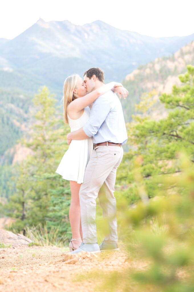 Couple embrace each other while exchanging a kiss during their engagement photo session in the Colorado mountains