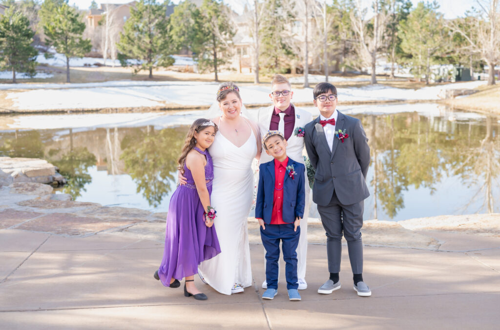 Brides standing next to their children for a family photo on their elopement day in Colorado Springs