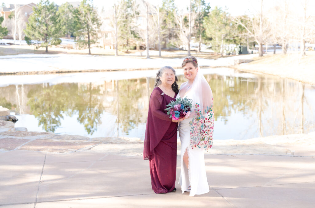 Bride standing next to her a mom for a photo at a park in Colorado Springs
