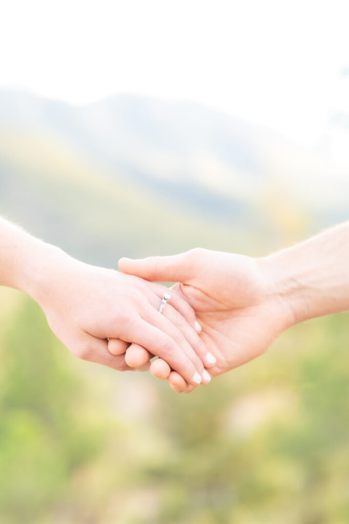 Closeup of couple's hands with engagement ring