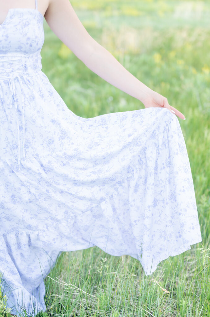 Detail picture of girl holding her dress out with her hand