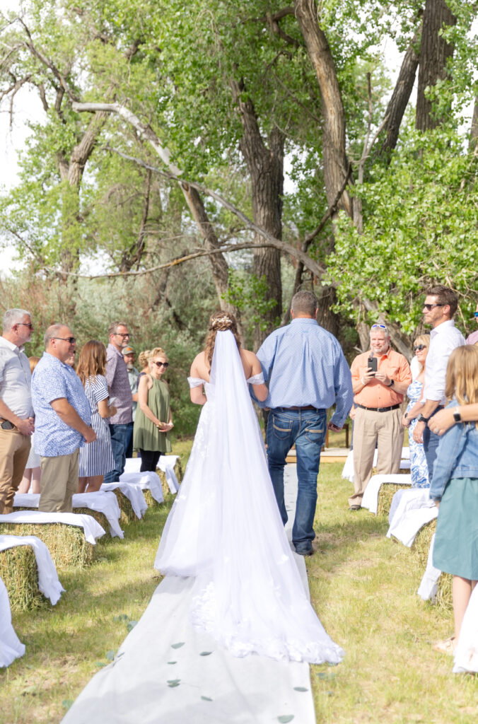 Bride's dad walking his daughter down the aisle during wedding ceremony 