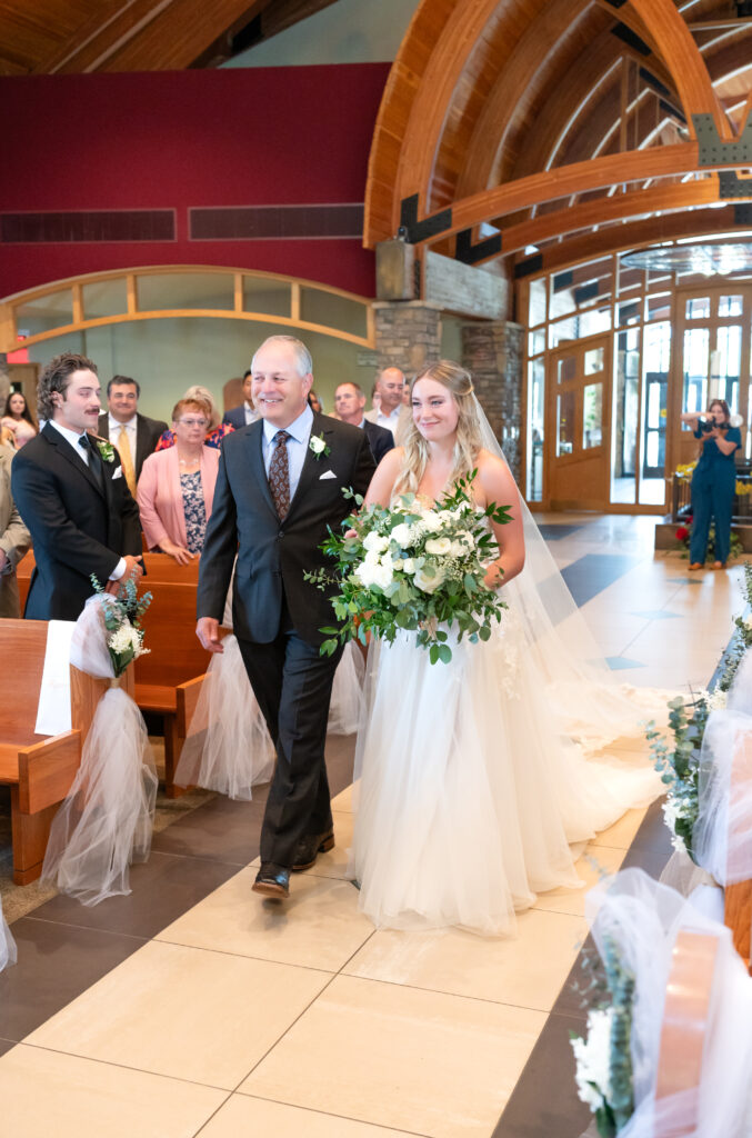 Bride's dad walking the bride down the aisle during Catholic Church ceremony on their Colorado wedding day 