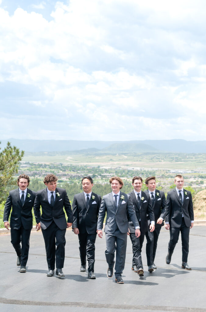 Photo of groom walking with his groomsmen on pavement on his wedding day in Colorado