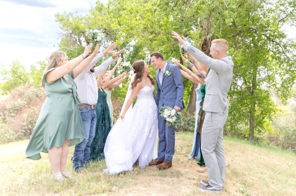 Wedding Party creating a tunnel for the bride and groom to run under to share a kiss on their colorado wedding day