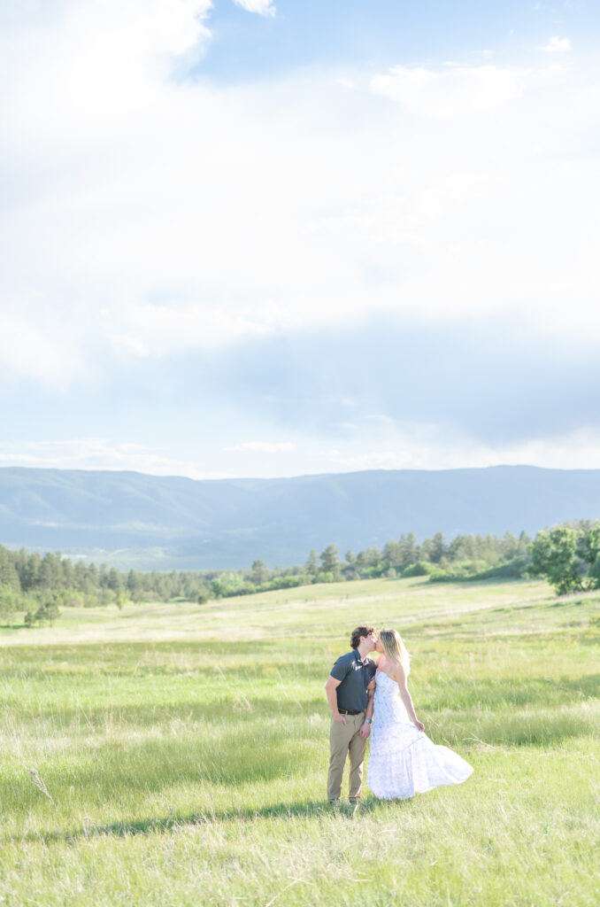 Couple kissing in an open meadow mountain field at Dawson Butte Open Space