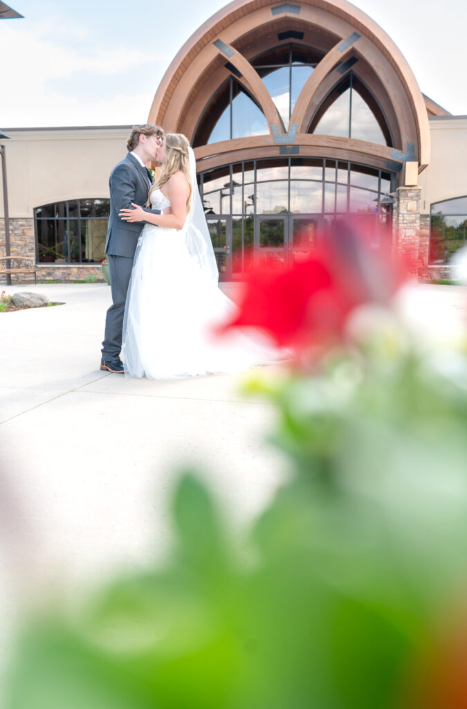 how to plan a wedding, bride and groom exchange a kiss outside wedding venue in Colorado Springs