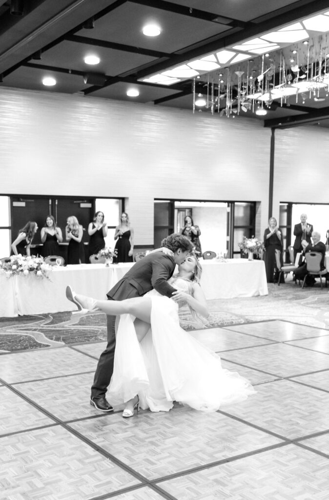 Groom dipping his wife for a romantic dip kiss on the dance floor during their Colorado wedding reception