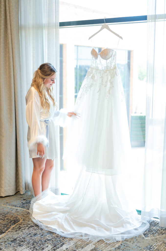 bride touching and admiring her dress she is wearing on her wedding day 