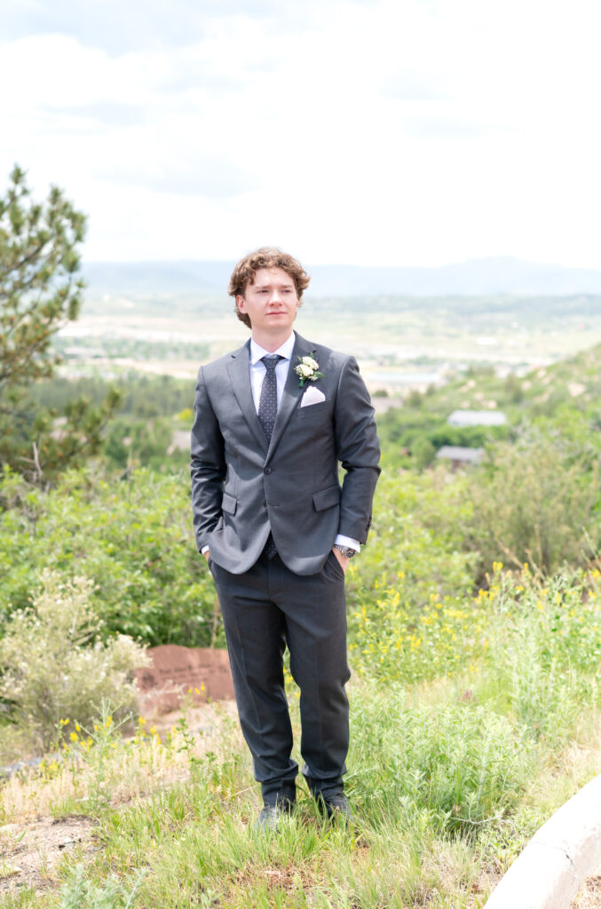 groom standing with his hands in his pockets while looking out into the distance