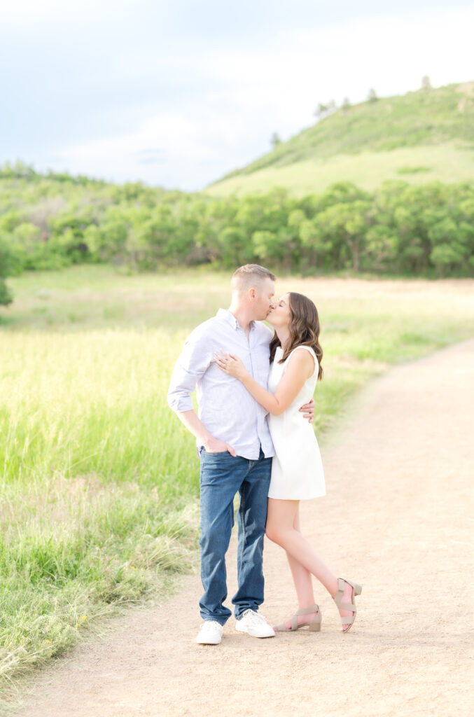 Couple sharing a kiss along dirt path trail at Roxborough State Park in Colorado