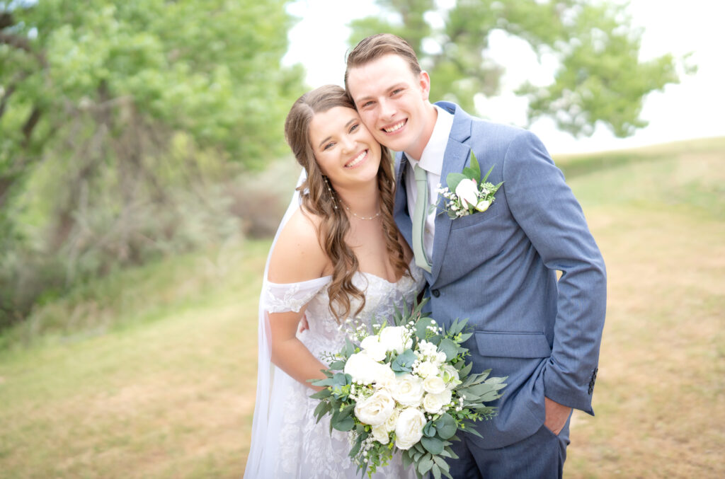 Bride and groom stand cheek-to-cheek on their Colorado wedding day