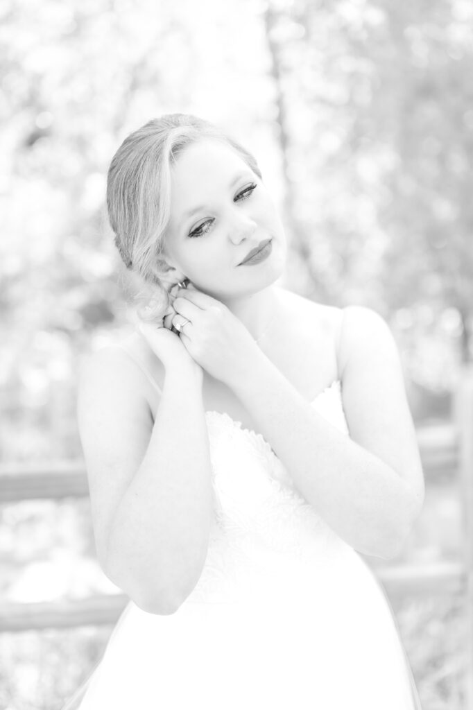 Bride raising her hands to fix her earrings on her Colorado Springs wedding day 