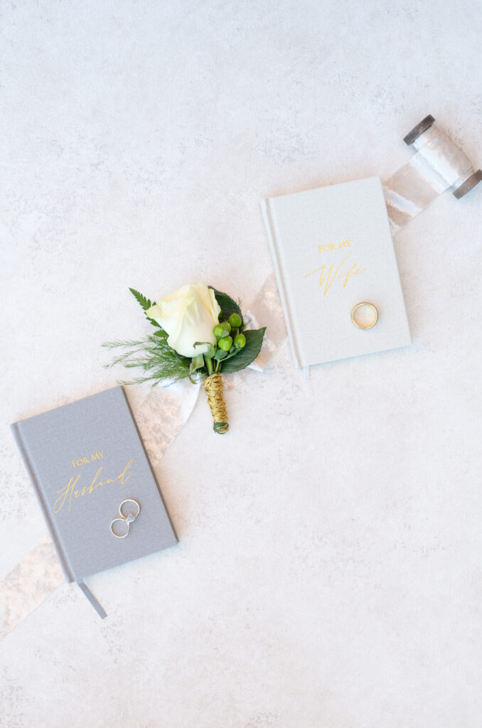 Boutonniere and vow books laying along string of ribbon, intimate Colorado Springs wedding day