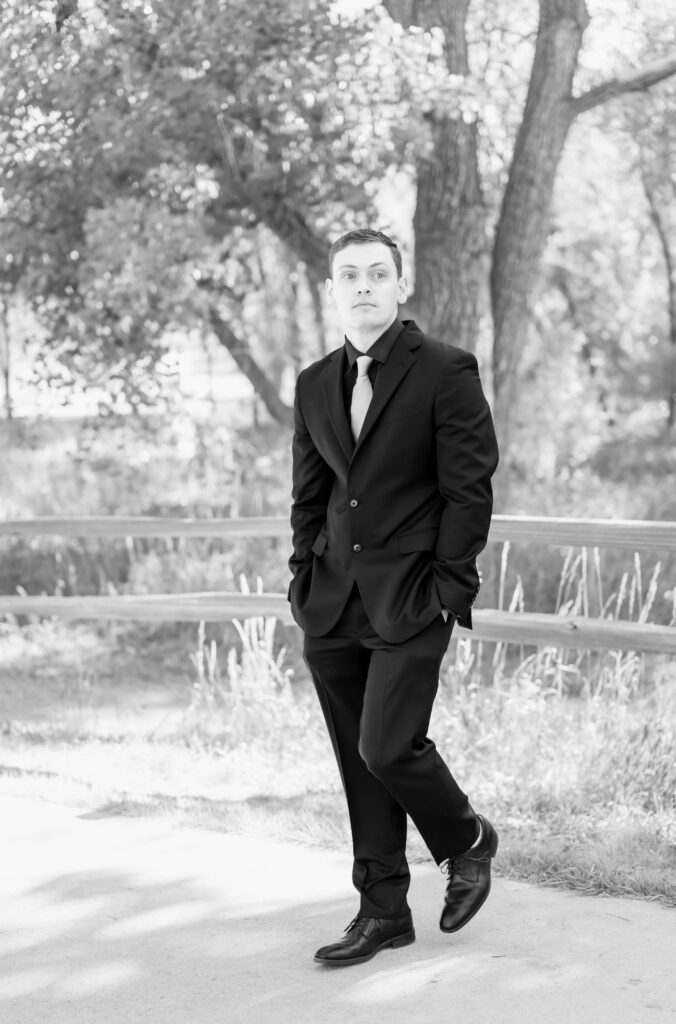 Groom walking along path while looking out into the distance on his wedding day in Colorado Springs 