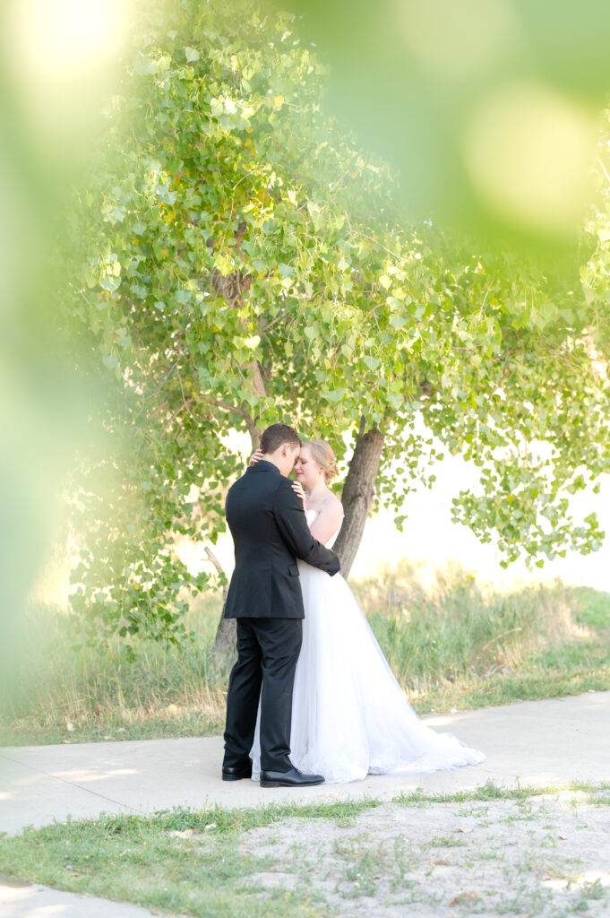 Bride and groom holding each other close while standing on the path for a intimate hug moment on their wedding day