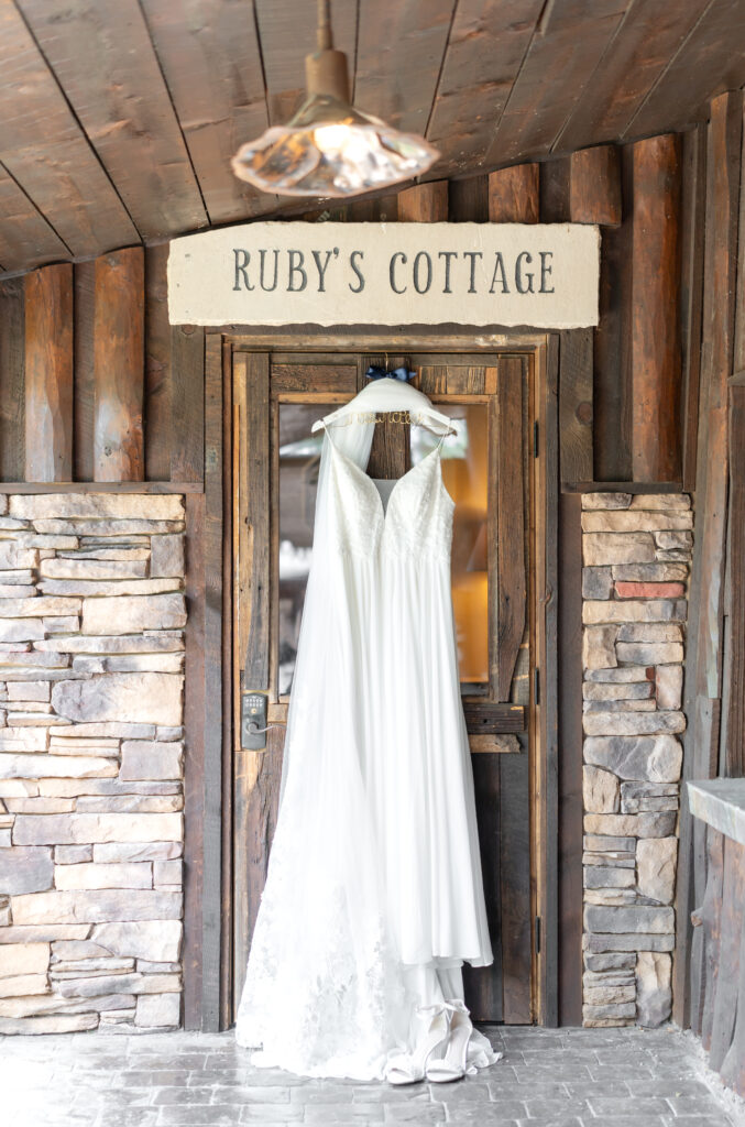 Bride's dress hanging on the door of Ruby's cottage at Spruce Mountain Ranch