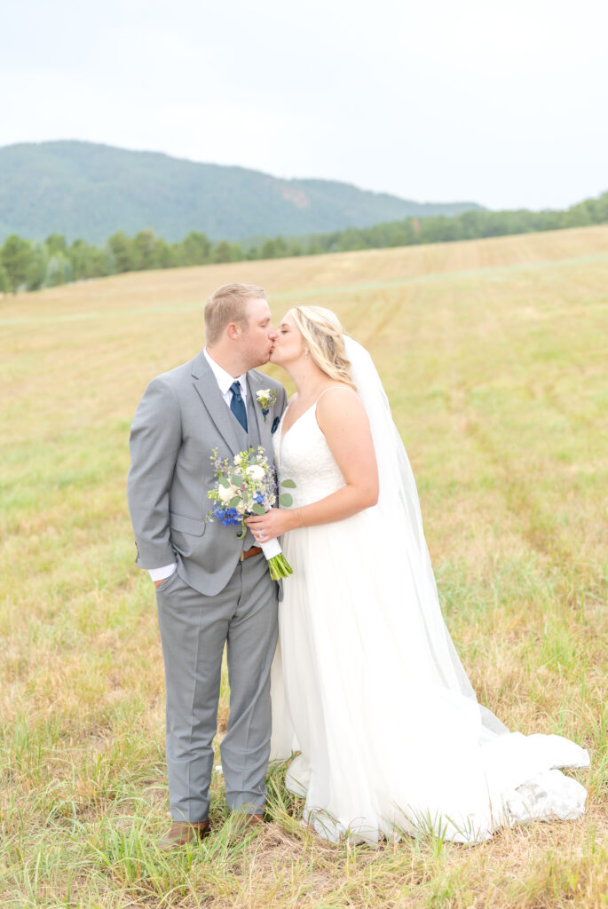 Bride and groom exchange a kiss during their couples portraits at Spruce Mountain Ranch