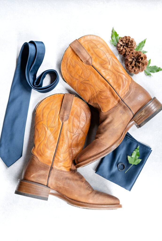 Groom's cowboy boots, blue necktie and pocket square, and wedding ring