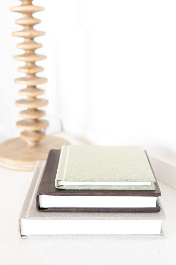 3 Heirloom photo albums bound in linen and leather, stacked on top of each other