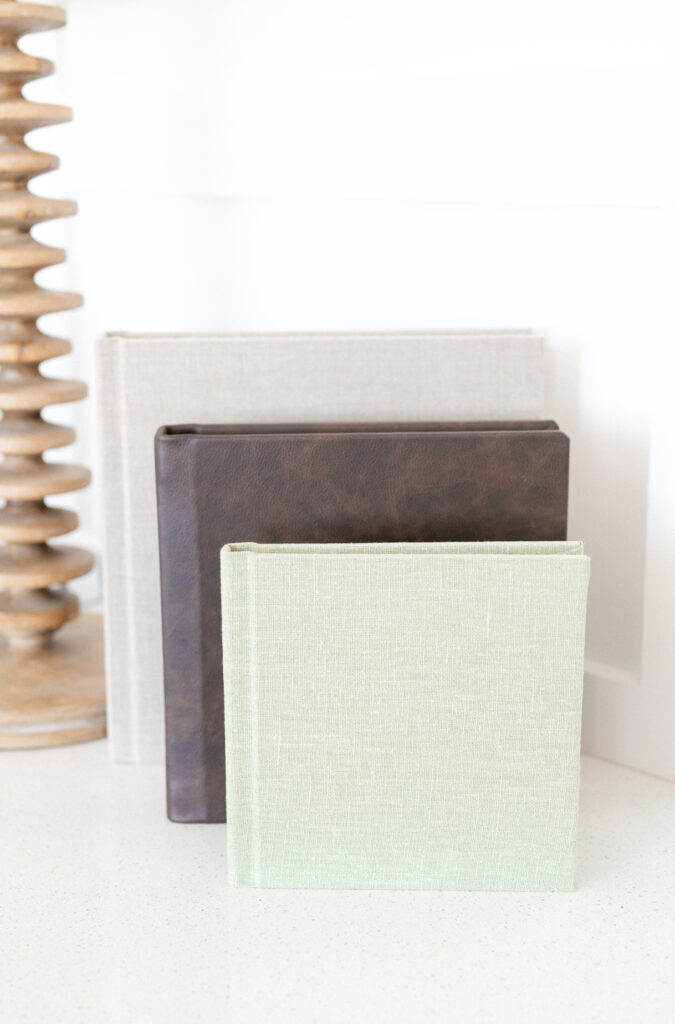 Photo books leaning on a mantelpiece against a wooden lamp