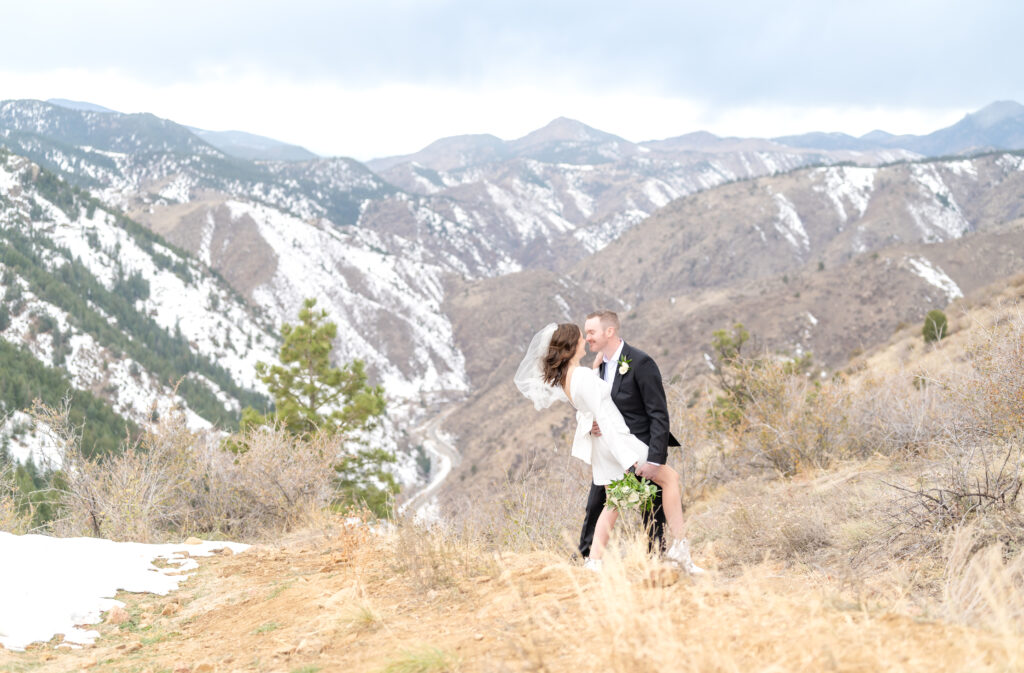 Groom dips his bride as he goes in for a kiss during their elopement at Lookout Mountain in Colorado