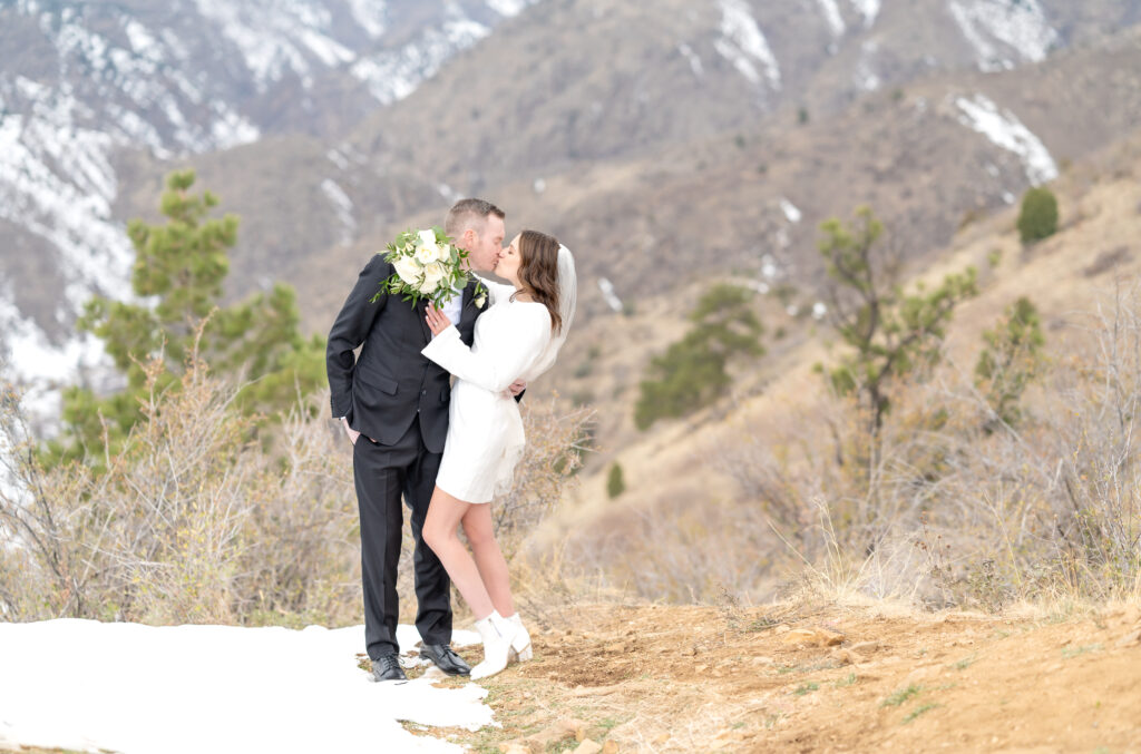 Landscape photo of the bride and groom sharing a soft, intimate kiss for their elopement photos at Lookout Mountain in Colorado