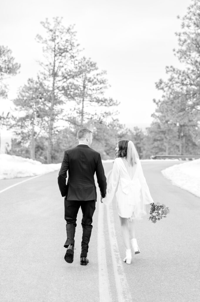 Bride and Groom lightly run and hold hands along the road together to celebrate their marriage at Lookout Mountain