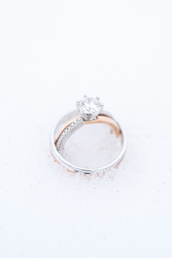 Closeup of the bride and groom's wedding rings in the snow