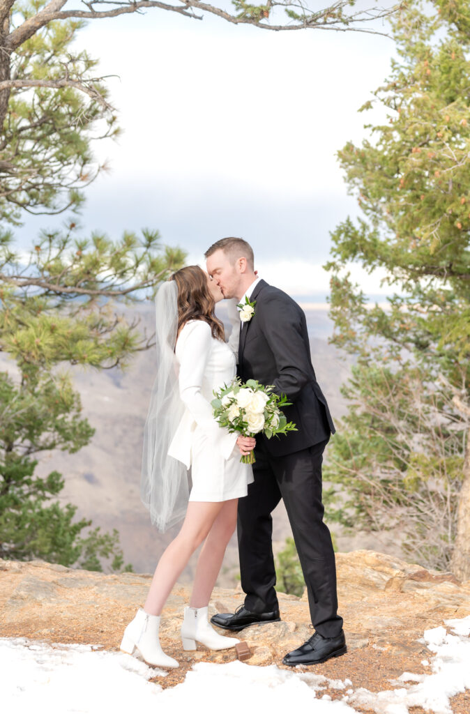 Bride and groom share their first kiss as husband and wife during their private elopement ceremony at Lookout Mountain in Colorado